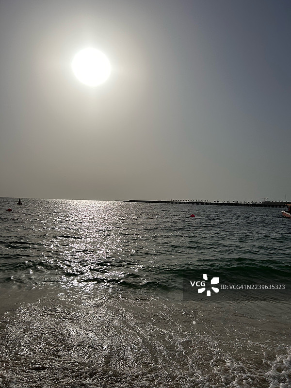 晴空下的日照海景与远方码头图片素材