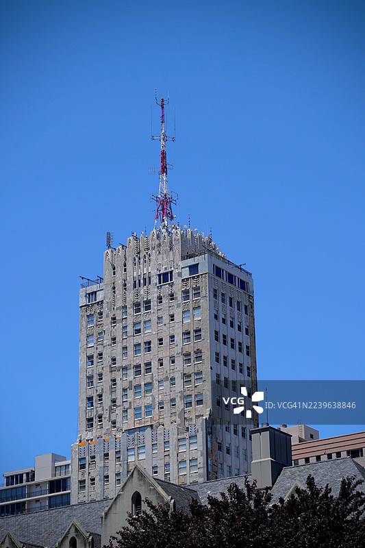 从低角度拍摄的古老建筑，配有通信天线，背景是湛蓝的天空，展示了城市建筑和技术，旧金山，美国，加利福尼亚州图片素材