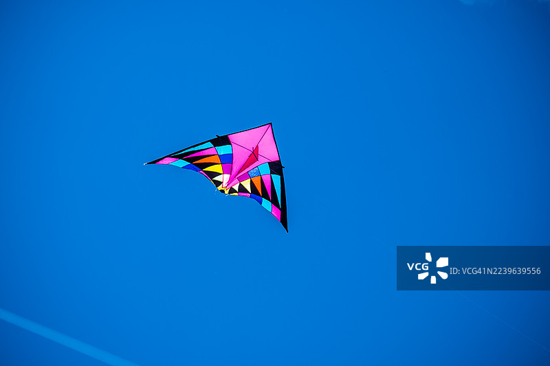 晴朗的蓝天，色彩鲜艳的风筝在阳光下翱翔图片素材