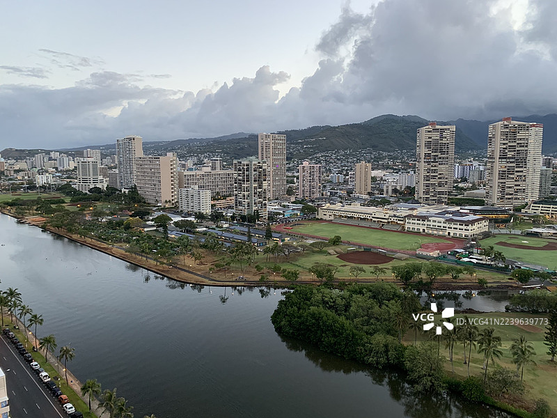 高角度拍摄的充满活力的城市，有河流、山脉，天空布满云层图片素材