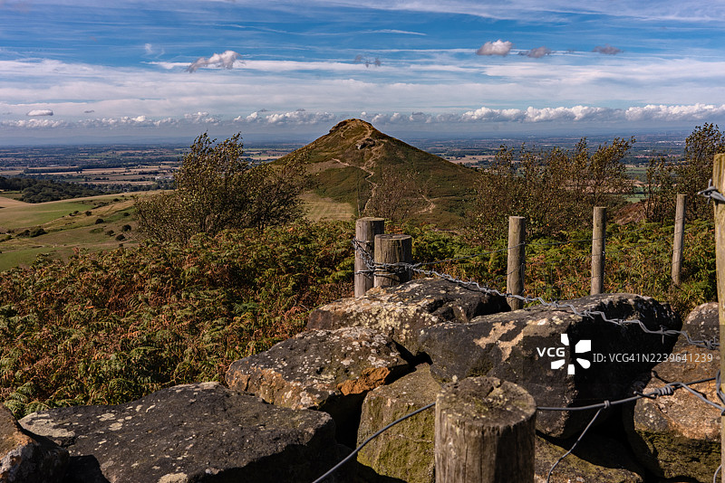 英国玫瑰贝里山顶的风景，有连绵的山丘和远处的山峰，蓝天白云。图片素材