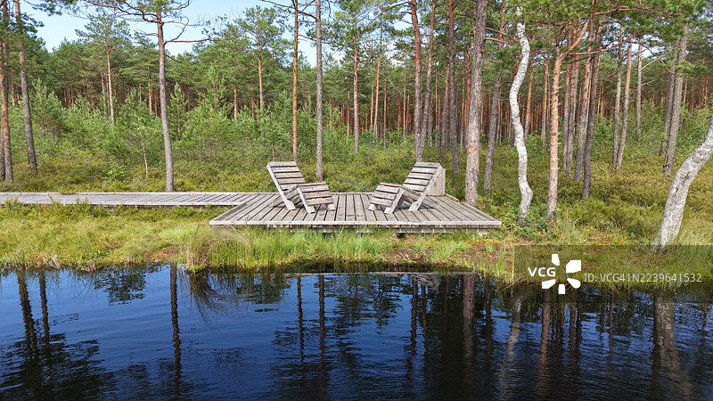 木制栈道和躺椅，俯瞰宁静的森林湖泊，非常适合放松和沉思自然，立陶宛维萨吉纳斯图片素材