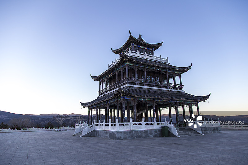 黄昏时分，中国传统风格的宝塔矗立在晴朗的天空下，远处是连绵的山峦，地点为中国太原。图片素材