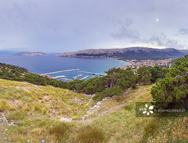 克罗地亚斯塔拉巴斯卡，全景视图，海边小镇，码头坐落于山丘与大海之间，天空布满云彩图片素材