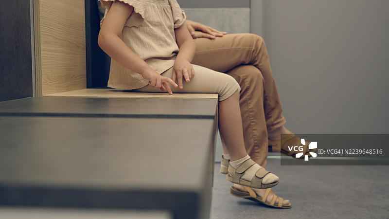 孩子在儿科医生办公室等候时，安静地和妈妈一起玩耍图片素材