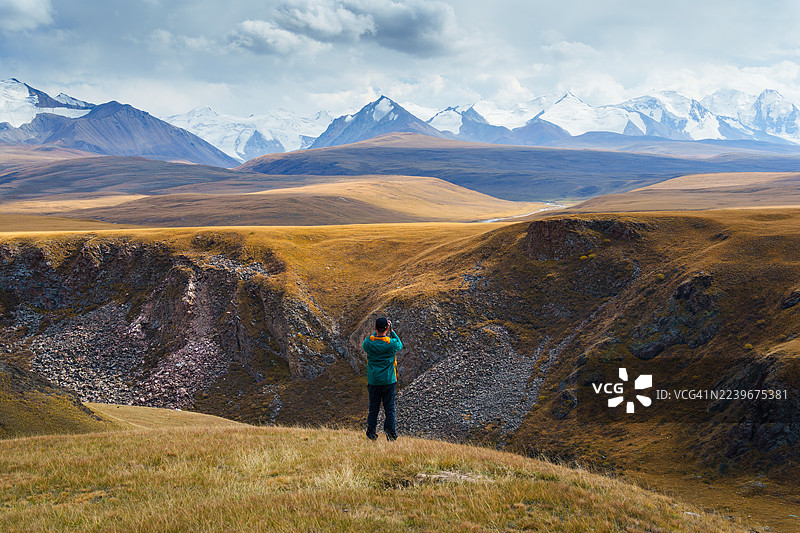 秋季，一名男子在吉尔吉斯斯坦的萨雷贾兹山谷探险。图片素材