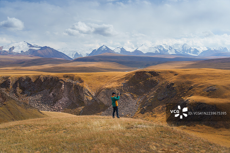 秋季，一名男子在吉尔吉斯斯坦的萨雷贾兹山谷探险图片素材