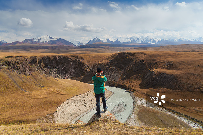 秋季，一名男子在吉尔吉斯斯坦的萨雷贾兹山谷探险图片素材
