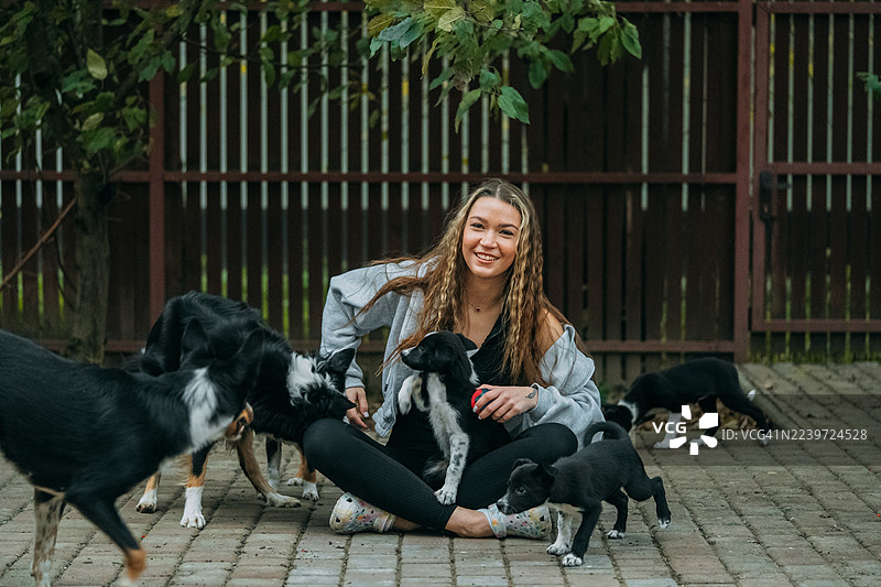年轻女子在户外抱着获救的小狗微笑图片素材