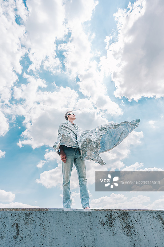 一个人裹着反光保温毯凝视天空图片素材