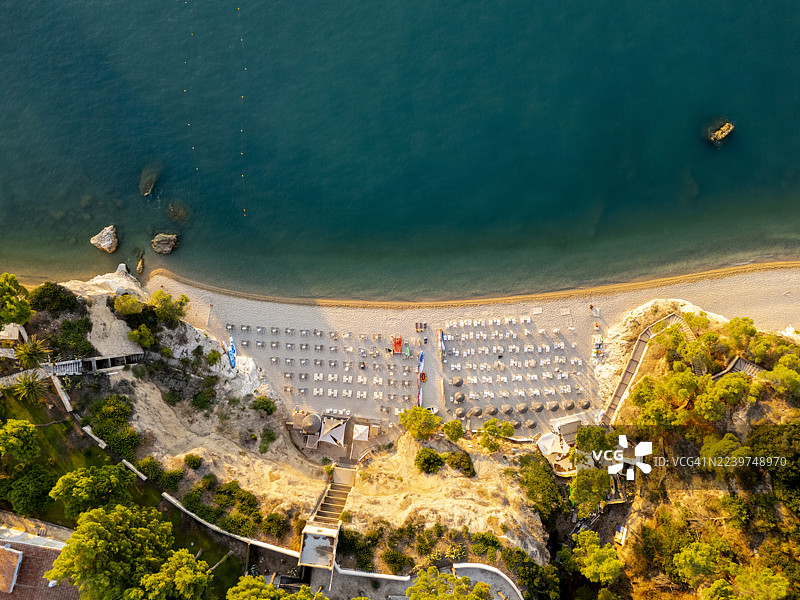 普利亚，意大利，隐秘海滩的鸟瞰图，配有太阳椅和绿松石般的海水，田园诗般的海岸风光图片素材