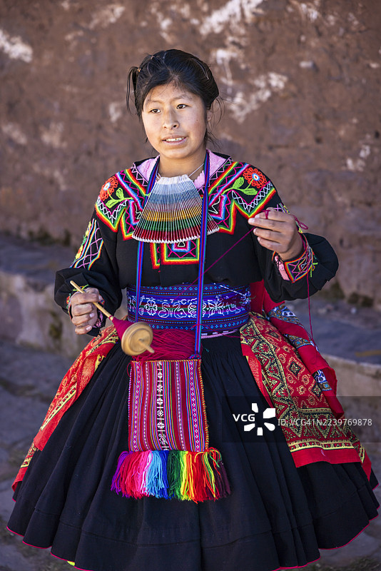 秘鲁的的喀喀湖塔基莱岛上一位年轻女子正在手工纺羊毛图片素材