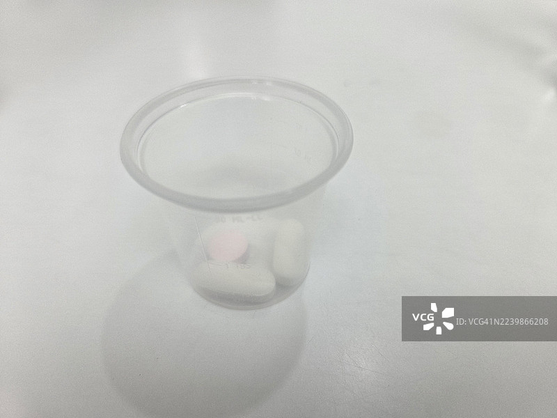 药片胶囊放在塑料杯中图片素材