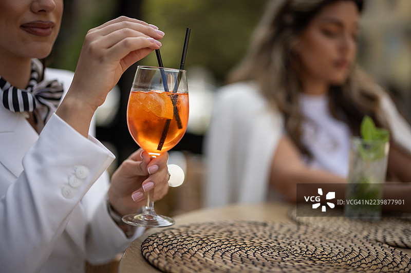 夏日傍晚，朋友们围坐在桌边，享用精致的户外鸡尾酒。图片素材