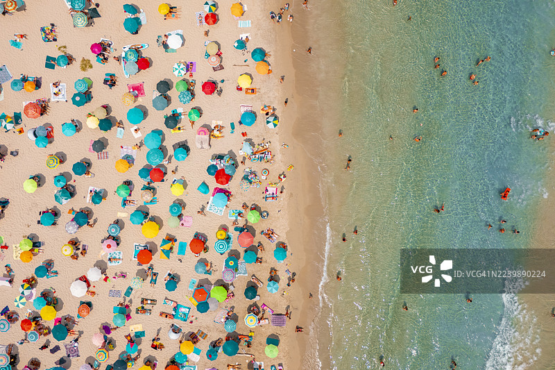 意大利普利亚地区，碧绿海水边的拥挤海滩，色彩缤纷的遮阳伞，鸟瞰图图片素材