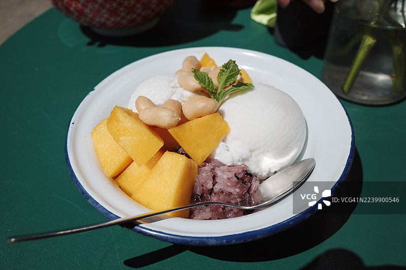 白釉碗盛装的泰式甜点，芒果糯米饭搭配椰子冰淇淋。图片素材