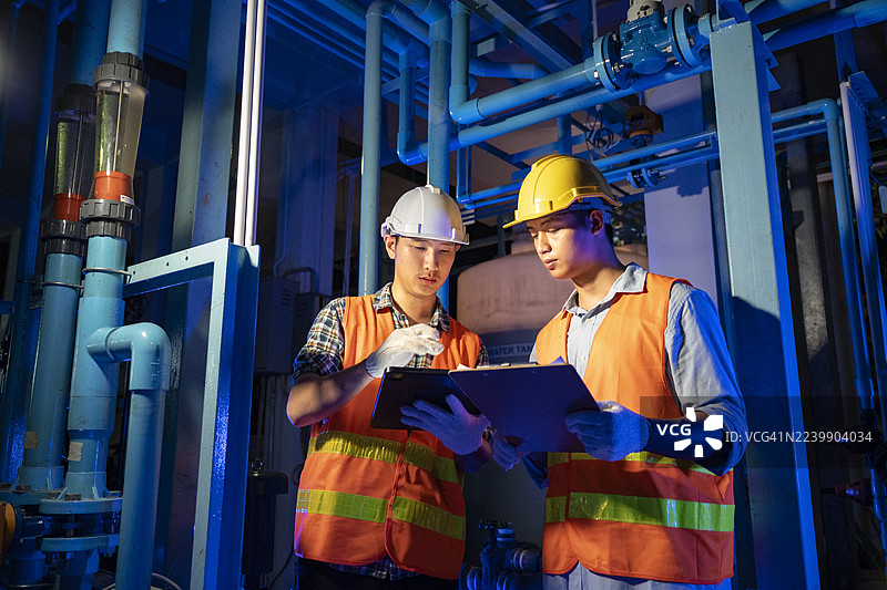亚洲男性工程师在工业设施中检查水管理和能源系统，确保安全合规图片素材