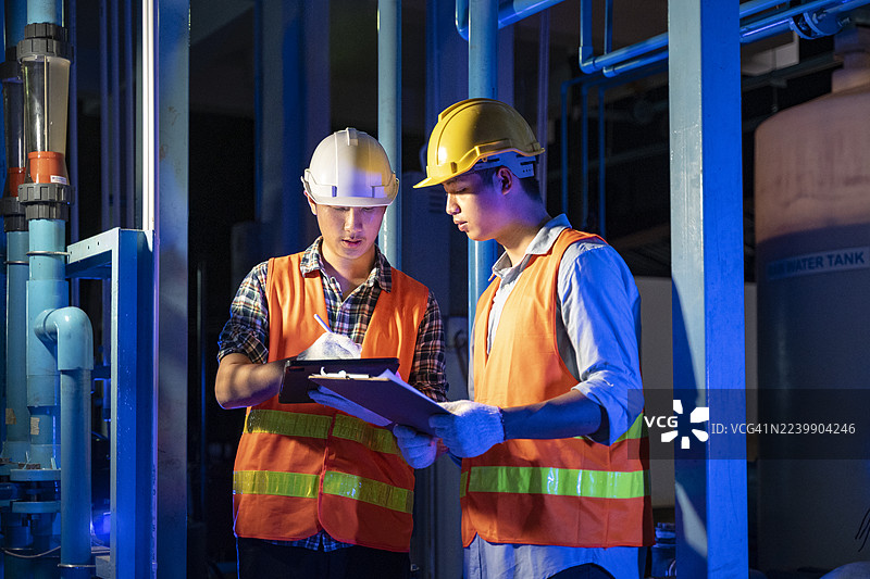 亚洲男性工程师在工业设施中检查水管理和能源系统，确保安全合规图片素材