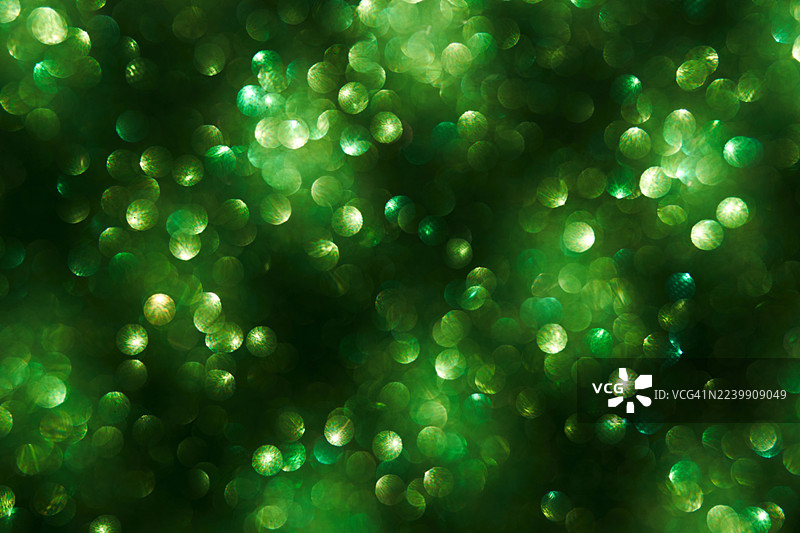 绿色散景灯光背景，带有柔和的圆形光斑，用于抽象节日设计和氛围营造。图片素材
