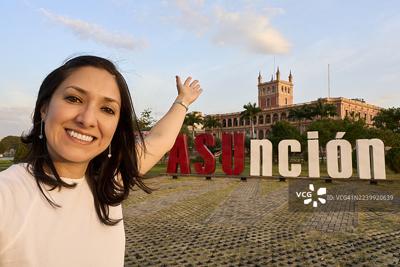 女子微笑着与亚松森城市标志合影自拍图片素材