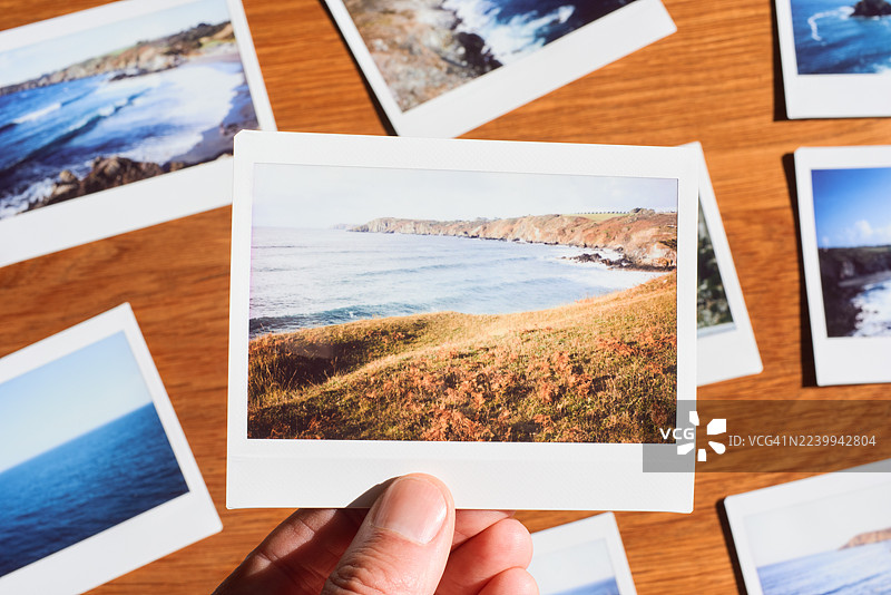 男人拿着一张即时成像照片图片素材