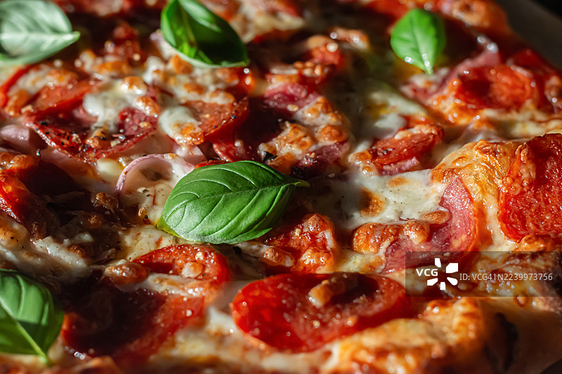 意大利萨拉米香肠、意大利熏火腿、番茄酱和香草的披萨。意大利辣香肠披萨。地中海美食。图片素材