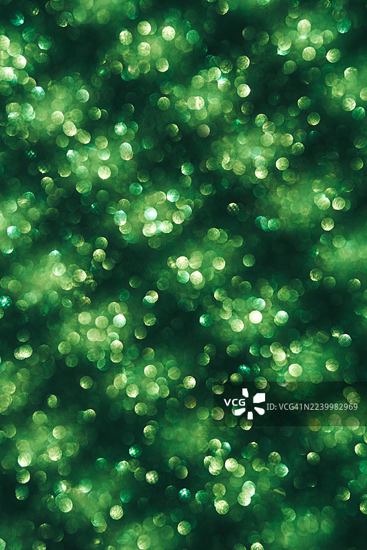 绿色散景光抽象背景，带有闪耀光芒和柔和圆形光球图片素材