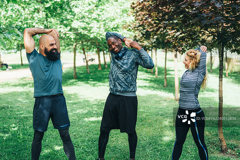 一群朋友在公园进行户外锻炼前的热身图片素材