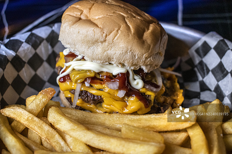 双层汉堡配馅料、土豆面包和炸薯条。快餐。美食。图片素材