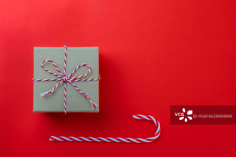 节日礼品交换的工艺礼品盒，配有红色麻绳和拐杖糖，背景为红色图片素材