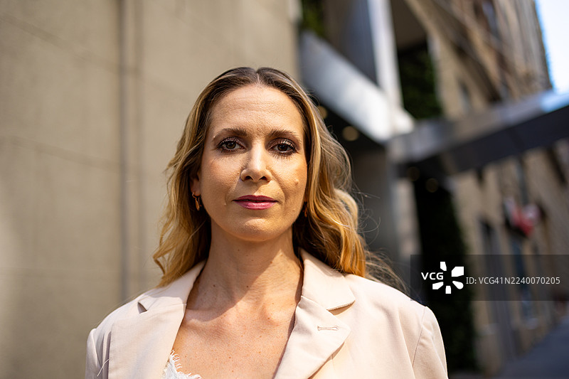自信的女性肖像，站在城市街道上，看向镜头图片素材