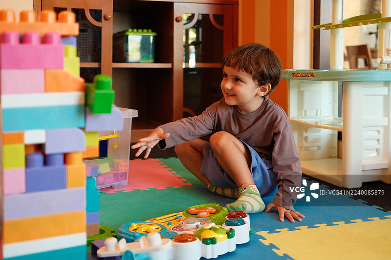 快乐的男孩玩彩色积木图片素材