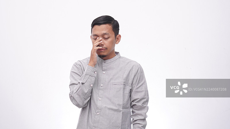 亚洲男子遭受剧烈眼痛，白色背景下的医疗保健概念，工作室拍摄图片素材