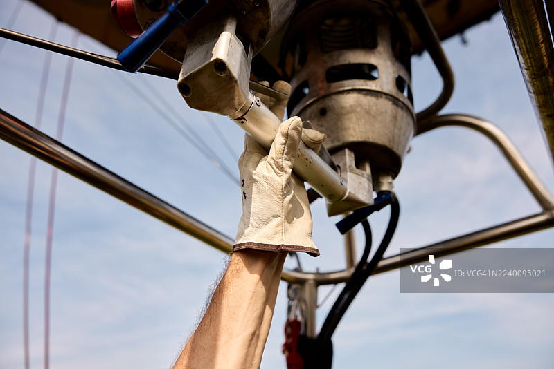 热气球飞行员正在操作燃烧器给球囊充气。图片素材