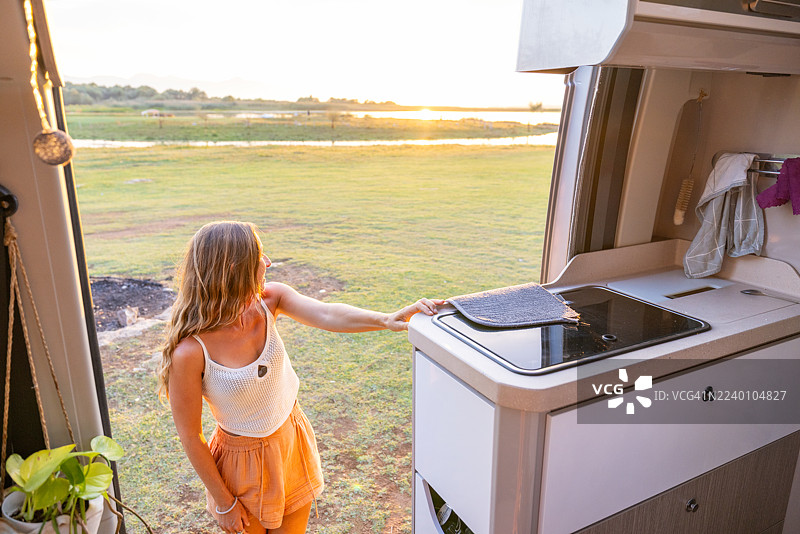 女人在房车厨房享受日落美景图片素材