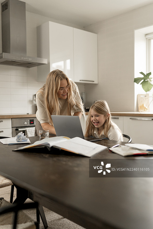 母女在家合作使用笔记本电脑，进行财务管理和学习。图片素材