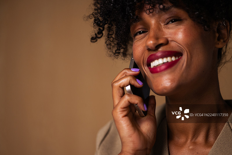 快乐的黑人女性正在微笑着打电话图片素材