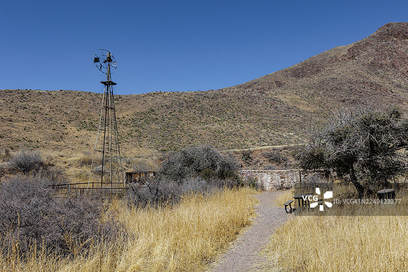 美国新墨西哥州器官山脉-沙漠峰国家纪念碑巴尔峡谷小径旁的野餐桌和废弃的风车图片素材