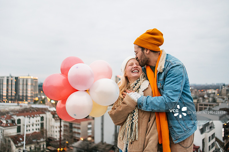 年轻情侣在城市屋顶庆祝生活中的小确幸——真实的都市爱情故事图片素材