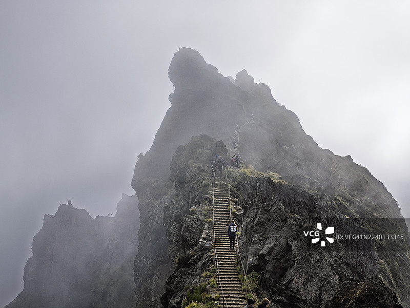 马德拉岛上，人们沿着陡峭的石阶小径徒步登山，欣赏壮丽的山景。图片素材