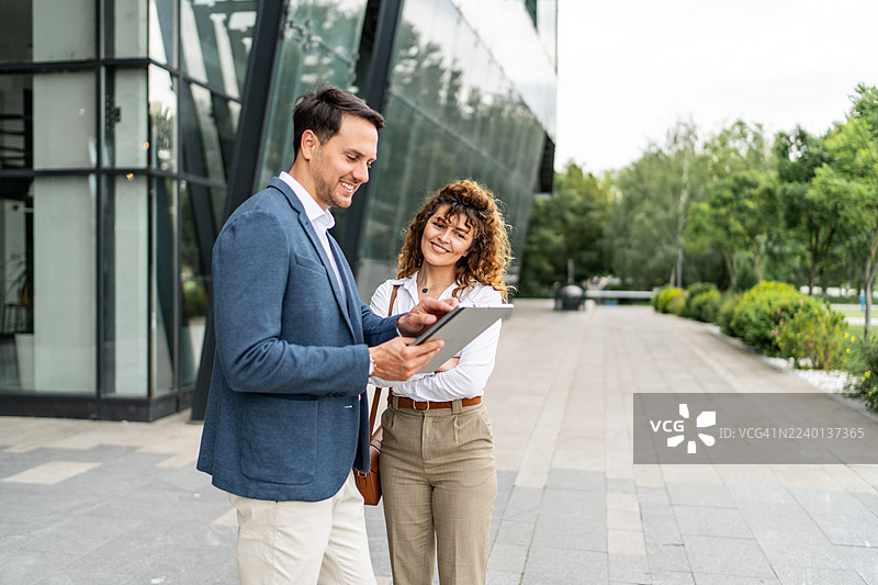 商务同事在户外使用平板电脑讨论项目图片素材