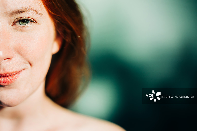 一位女士面部的特写肖像，带着温柔的微笑，眼睛直视镜头。图片素材