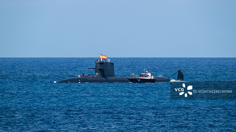 西班牙S-80 Plus级军用潜艇在清澈的海水中航行，由一艘领航船协助图片素材