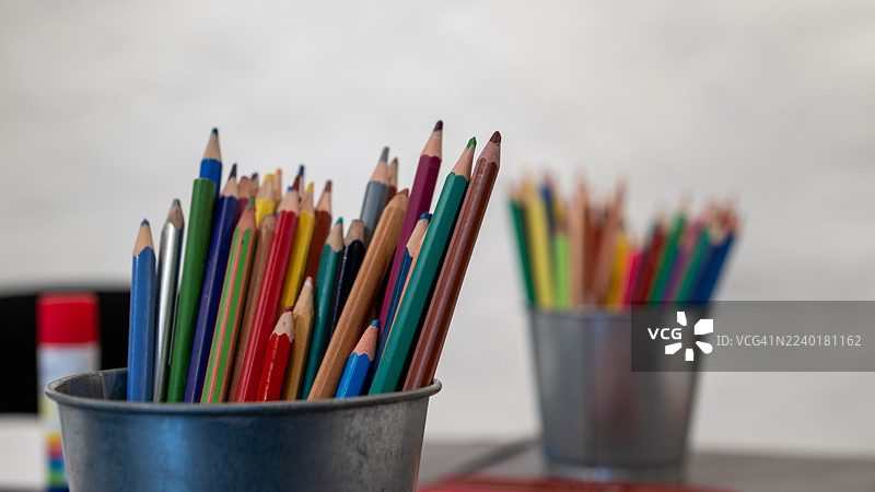 五颜六色的铅笔整齐地立在金属罐中，随时准备用于艺术和手工创作。图片素材