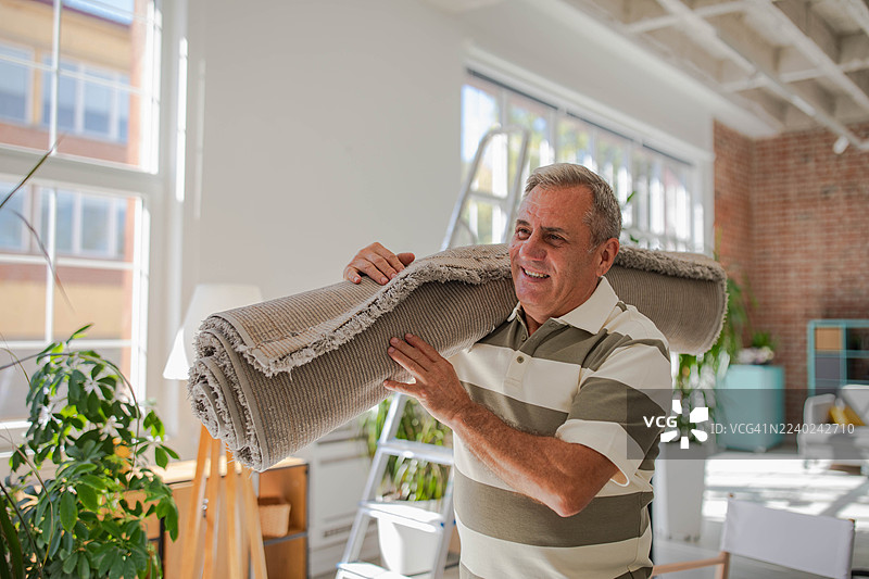 一位面带微笑的老年男子搬入新公寓图片素材