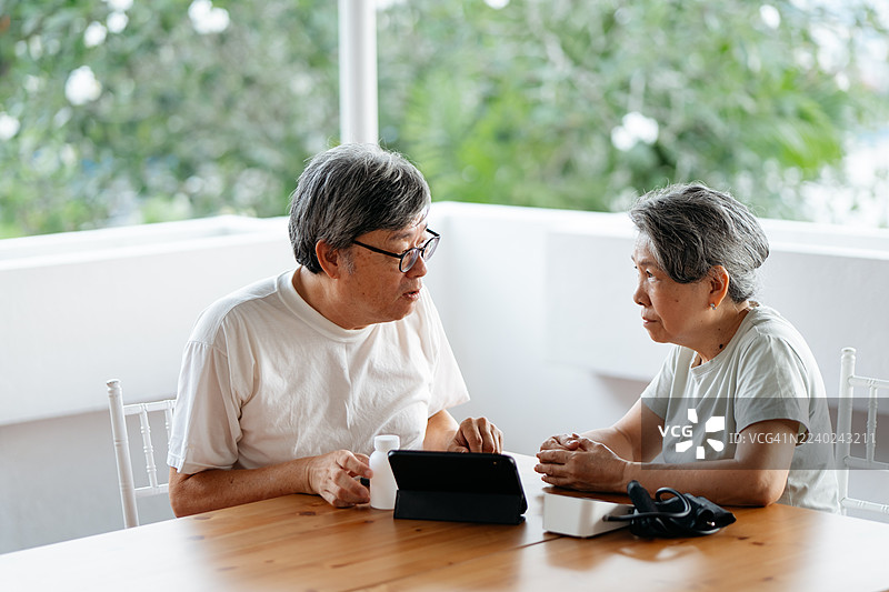 老年夫妇使用数码设备讨论信息图片素材