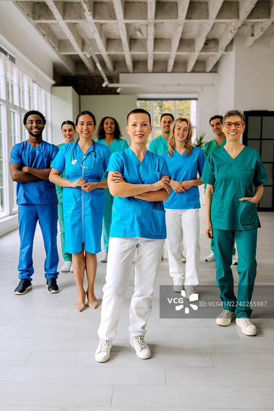 一群医务工作者在镜头前合影，其中一名女医生在前排。图片素材