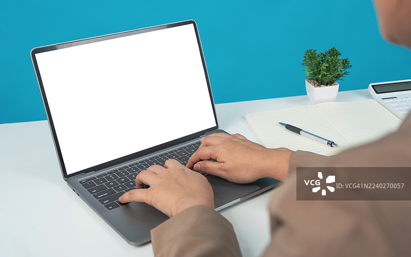 背景为浅蓝色的空白白色屏幕的笔记本电脑，一名女子正在使用和打字，孤立。女商人的手在数字屏幕上工作。屏幕上有网络和网页设计。规划。搜索和打字以连接互联网的技术。图片素材