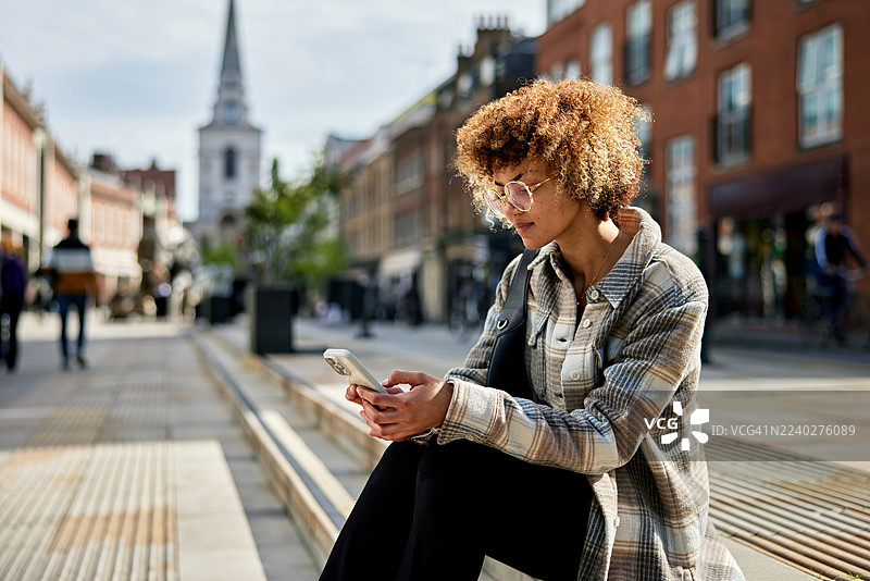 办公室职员在户外用智能手机休息图片素材