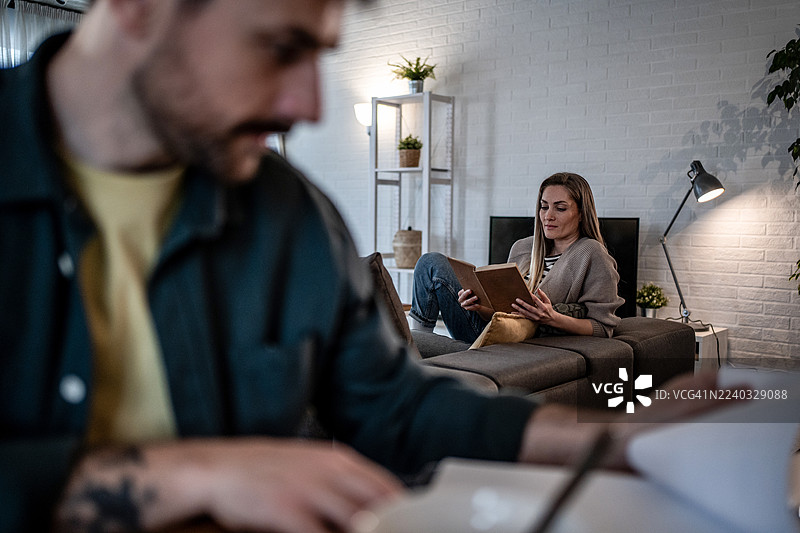 夫妇在家放松，在客厅读书图片素材